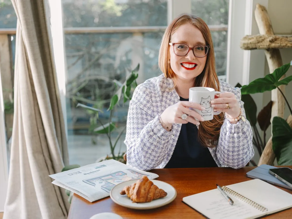 Dr. Monica smiling with a mug at her desk